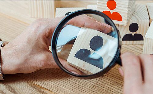 Professionnel qui regarde un papier en forme de personne avec une loupe, Certificat Relations sociales en formation continue, Université Paris Dauphine-PSL