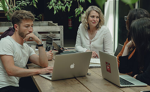 Un groupe de professionnels SCOP travaillant dans une salle de réunion avec un ordinateur. Diplôme d'Université Business Management parcours SCOP, formation continue de Dauphine Executive Education